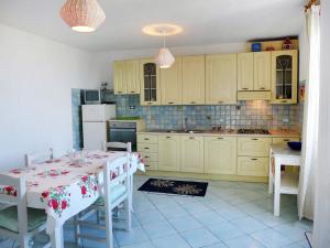 a kitchen with a table and a kitchen with yellow cabinets at Holiday Home The Pink by Interhome in Ischia