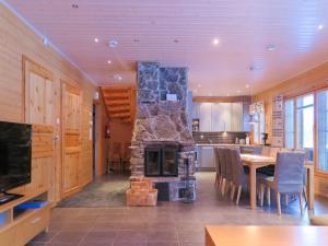 sala de estar con chimenea de piedra en la cocina en Holiday Home Hiihtogreeni a by Interhome en Sirkka