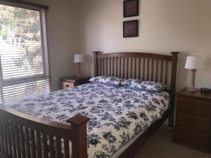 Schlafzimmer mit einem Bett mit einer blauen und weißen Bettdecke in der Unterkunft Casa Dolce Casa in Rye