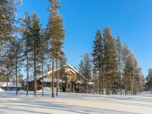 a log home in the snow with trees at Holiday Home Hiihtogreeni b by Interhome in Sirkka