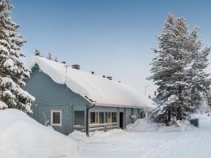 a blue house with snow on the roof at Holiday Home Kiehislevi a in Sirkka