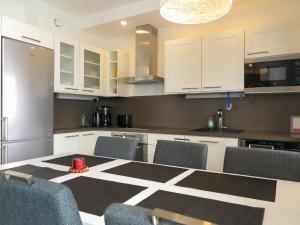 una cocina con armarios blancos y una mesa con sillas. en Holiday Home Kotka b by Interhome, en Saariselkä