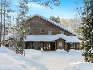 a large wooden house in the snow at Holiday Home Hiihtogreeni a by Interhome in Sirkka