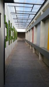 HOTEL EIFFEL في إنسينادا: ممر فارغ لمبنى فيه نباتات على الجدران