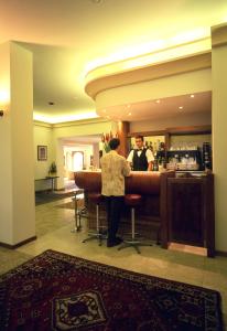 a man standing at a bar in a hotel at Albergo Paradiso in Montecatini Terme