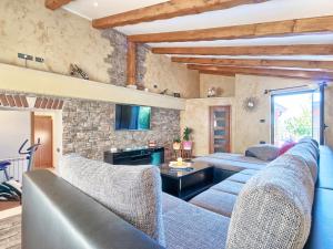 salon z niebieskimi kanapami i kamienną ścianą w obiekcie Holiday Home Darija by Interhome w mieście Villanuova