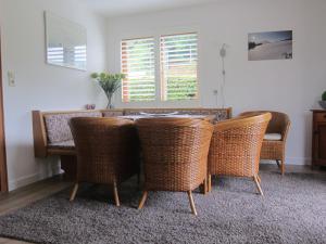 a dining room with a table and wicker chairs at Huis Fitaniki in Leogang