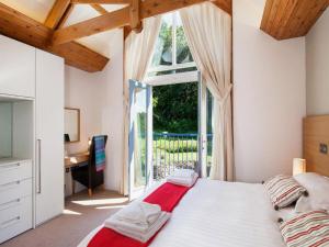 a bedroom with a bed and a desk and a window at Holiday Home The Valley by Interhome in Perranwell