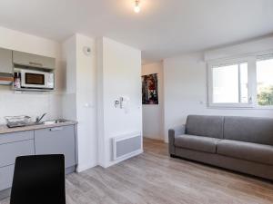 een woonkamer met een bank en een keuken bij Studio Apsara by Interhome in Saint-Malo