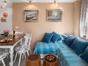 a living room with a blue couch and a table at Holiday Home Villa Aurora by Interhome in Loborika