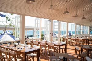 a restaurant with wooden tables and chairs and windows at Portsea Hotel in Portsea