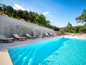 - une piscine avec des chaises longues à côté d'un mur dans l'établissement Holiday Home Lapis by Interhome, à Buzet
