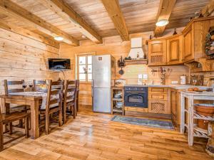 a kitchen with a refrigerator and a table and chairs at Chalet Plitvice I by Interhome in Rudanovac +10 photos
