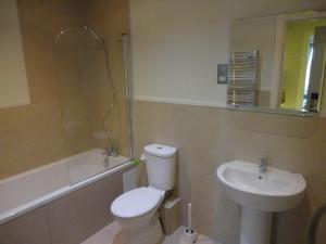 a bathroom with a sink, toilet and bathtub at Palmerston Suites in Edinburgh