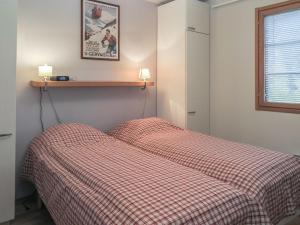 1 dormitorio con 1 cama con manta a cuadros en Holiday Home Tahko 4seasons 3 by Interhome, en Tahkovuori