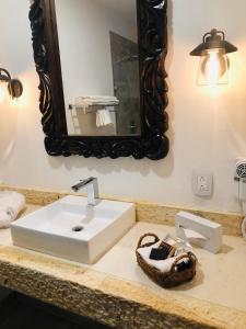 a bathroom with a white sink and a mirror at Casa de Adobe Gallery & Luxury Boutique in Oaxaca City
