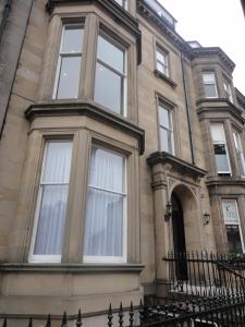 ein großes Gebäude mit Fenstern und einem Zaun in der Unterkunft Palmerston Suites in Edinburgh