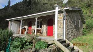 Cette petite maison en pierre est dotée d'une porte rouge. dans l'établissement Provence Cottage, à Carterton