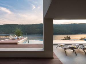 een balkon met uitzicht op een meer en 2 stoelen bij Villa Vlastelini II by Interhome in (( Hrvatini ))