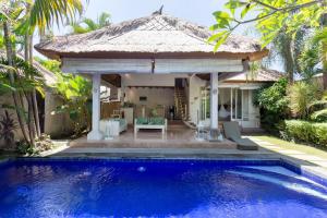 a villa with a pool and a gazebo at Villa Bliss a paradise of three independent Villas in Canggu