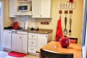 uma cozinha com armários brancos e uma mesa com um vaso vermelho em 1-Bedroom Cozy Sweet #22 by Amazing Property Rentals em Gatineau