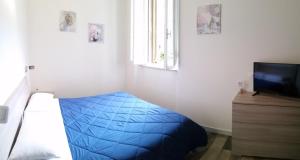 una camera con letto blu e televisore di A Casa di Asia a Grosseto