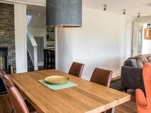a dining room with a wooden table and chairs at Holiday Home Taobh na Mara by Interhome in Kensaleyre
