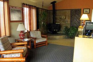 sala de estar con sofá, sillas y chimenea en Color Country Motel, en Panguitch