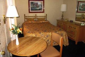 潘圭奇的住宿－彩色鄉村汽車旅館，酒店客房配有一张床铺、一张桌子和一张书桌。