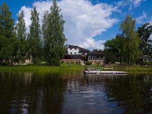 a boat on the water in front of a house at LVM tūrisma un atpūtas centrs "Ezernieki" in Meirāni