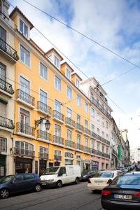 a large yellow building with cars parked in front of it at Lisbon Rentals Chiado in Lisbon