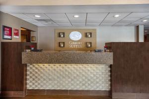 a lobby with a counter with a sign that reads convert suites at Comfort Suites in Green Bay