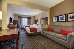 a hotel room with a bed and a couch at Comfort Suites Green Bay West in Green Bay