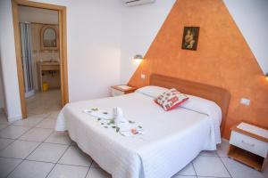 a bedroom with a white bed with an orange wall at Haidi House in Agerola +68 photos