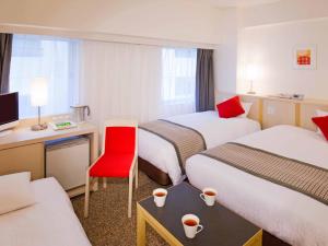una habitación de hotel con 2 camas y una silla roja en Rembrandt Style Tokyo Nishikasai en Tokio