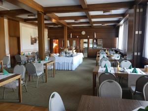 羅伊特林根的住宿－修道院磨坊餐廳酒店，一间带桌椅和时钟的用餐室