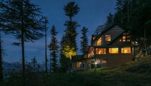 a house on top of a hill at night at StayVista at The Corner House - Pet Friendly Villa in Shimla