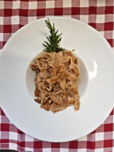 a white plate of food on a table at Ostello Brembo in Camerata Cornello