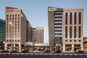 a city with cars parked in front of buildings at ibis Deira Creekside Dubai in Dubai