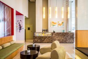 a lobby with chairs and tables and a counter at ibis Deira Creekside Dubai in Dubai