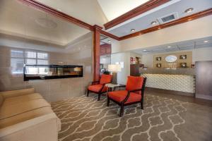 a hotel room with a couch and a table and chairs at Comfort Suites Green Bay West in Green Bay