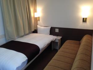 una camera d'albergo con due letti e due lampade di Hotel Sambancho a Matsuyama
