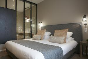 ランゴンにあるLogis Hôtel - Restaurant Maison Claude Darrozeのベッドルーム(大型ベッド1台付)、バスルームが備わります。