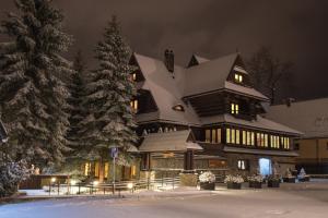 a large house with a snow covered roof at Pensjonat Jastrzębia Turnia in Zakopane