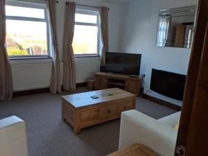 a living room with a couch and a tv at Avon House in Telford