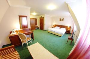 a hotel room with a bed and a desk at Jaśminowy Dwór in Rokietnica