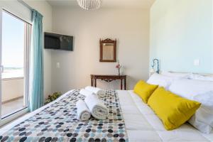 a bedroom with a bed with towels on it at Kyma seaview Apartments, Episkopi beach Rethymno in Karotí