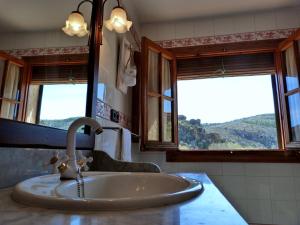 a bathroom with a sink and two windows at Las mil y una noches in Tramacastilla +28 photos