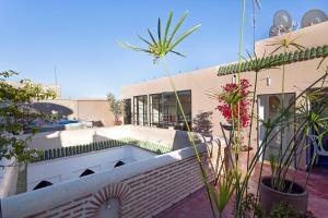 a house with a swimming pool on a balcony with plants at Riad Mirage in Marrakech