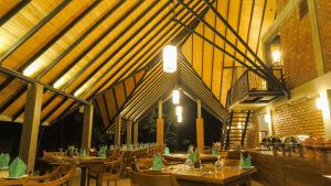 Go Go Green Resort في هارابانا: مطعم بطاولات وكراسي خشبية في مبنى